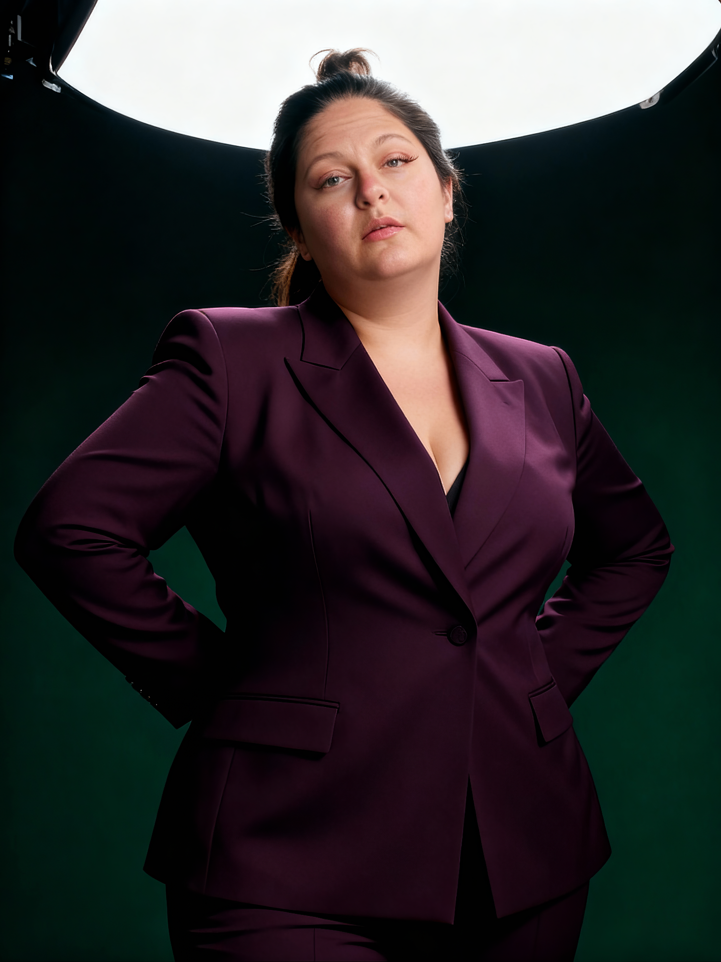 Portrait of Stacey Martinez in a deep plum suit under studio light